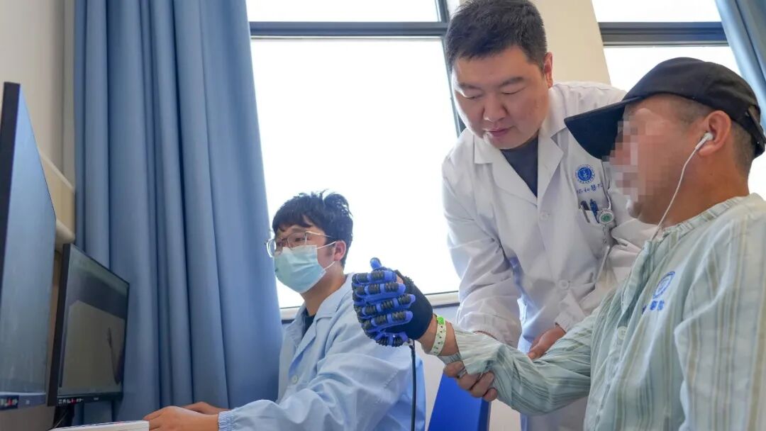 医生与工程师指导患者进行康复训练。通讯员刘坤维 摄