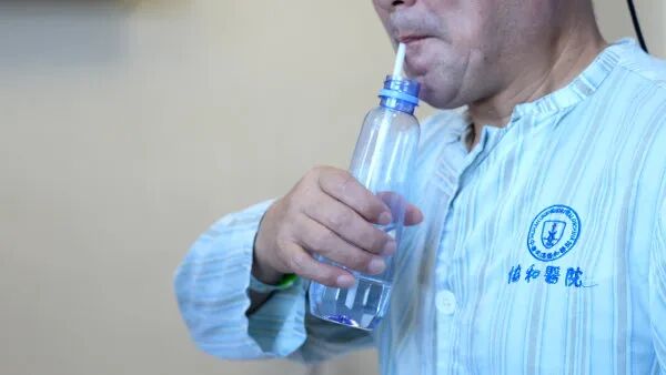 术后两个月，刘在德可以自主握水瓶喝水。通讯员刘坤维 摄